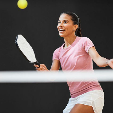 Image of woman playing pickleball
